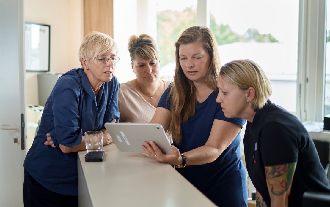 Pflegekräfte schauen auf Tablet